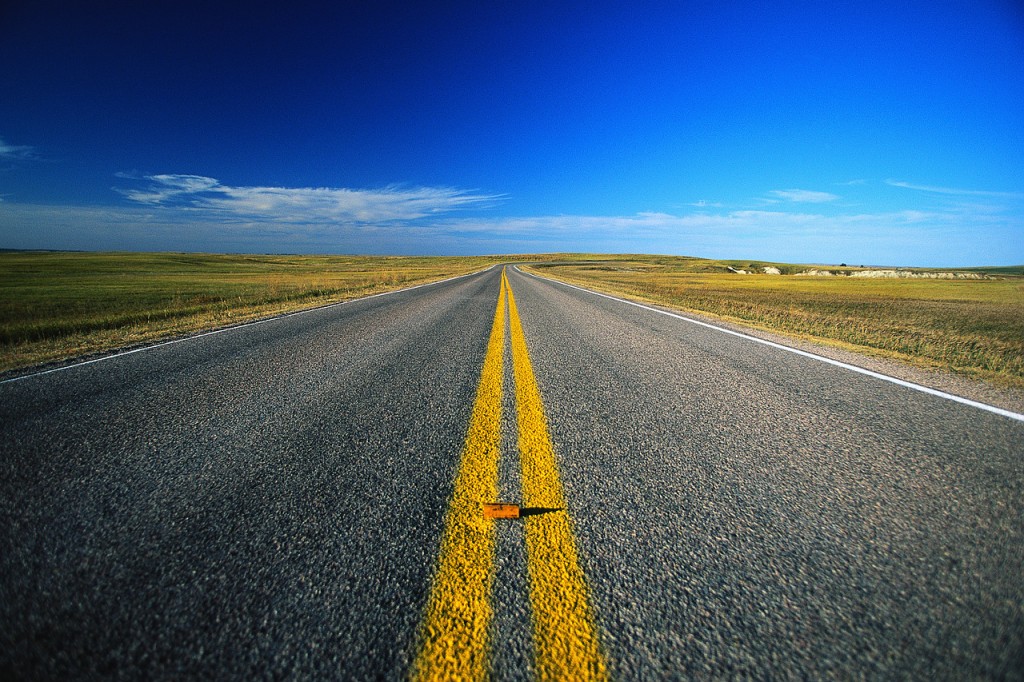 Een open weg die door het landschap naar de horizon loopt